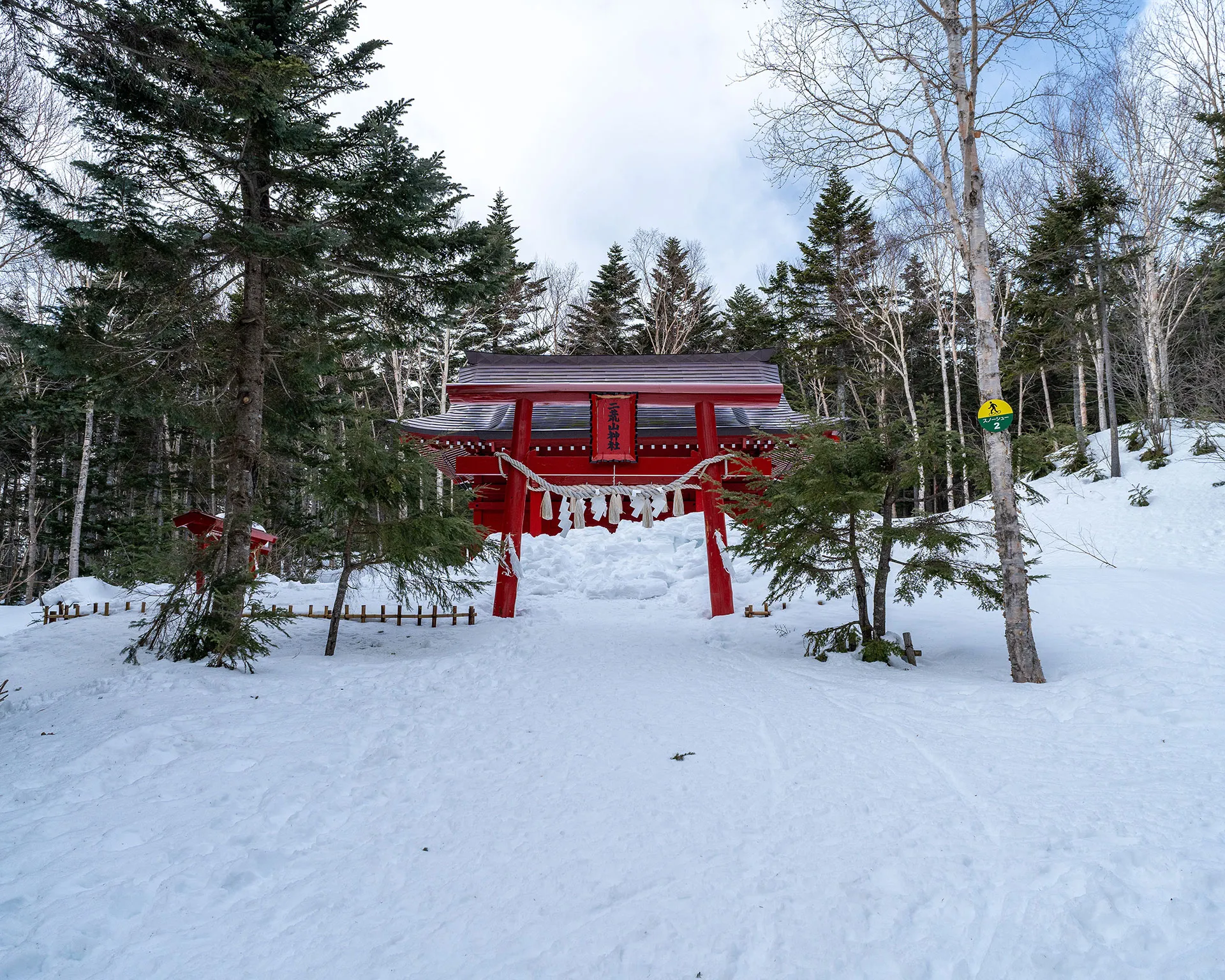 雪の中に佇む日光白根山登山口の「日光二荒山神社」の赤い鳥居。厳冬期の静かな登山口の風景。