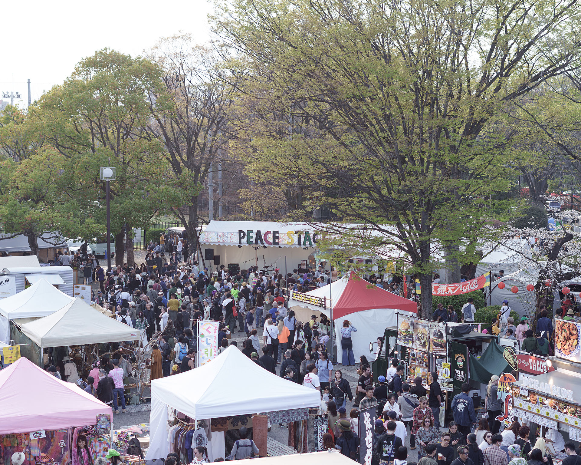 SPRING LOVE 春風のイベント会場。PEACE STAGEの周りに色とりどりのテントや屋台が並び賑わう様子。