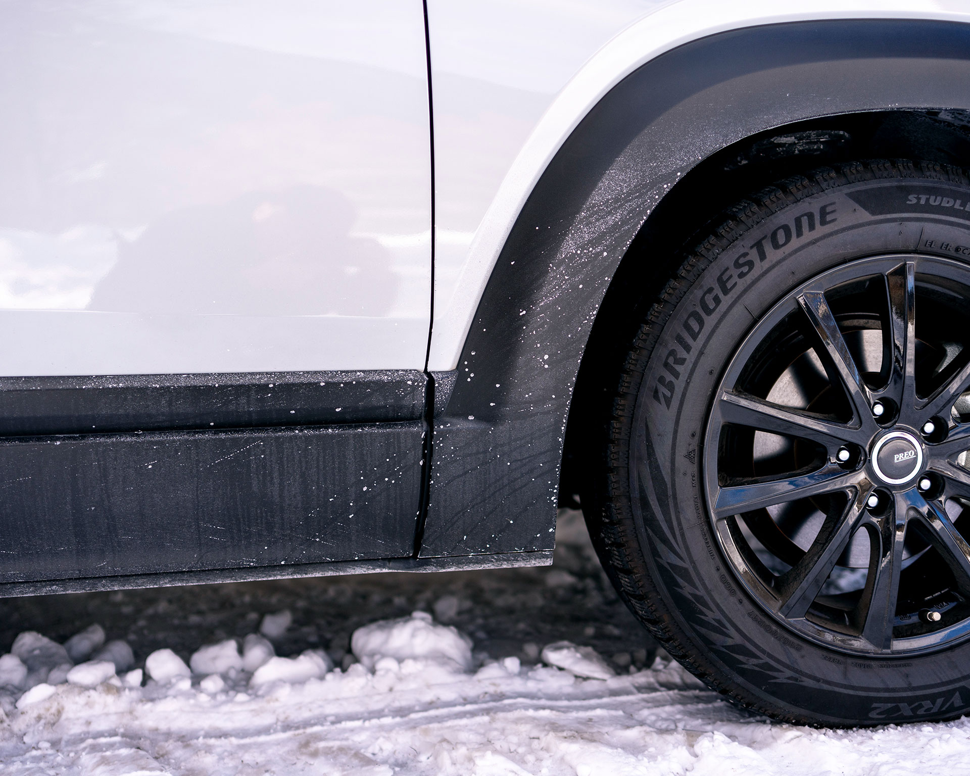 雪山でのMX-30のタイヤとボディ部分、ブリヂストンのスタッドレスタイヤと雪道走行後の車体