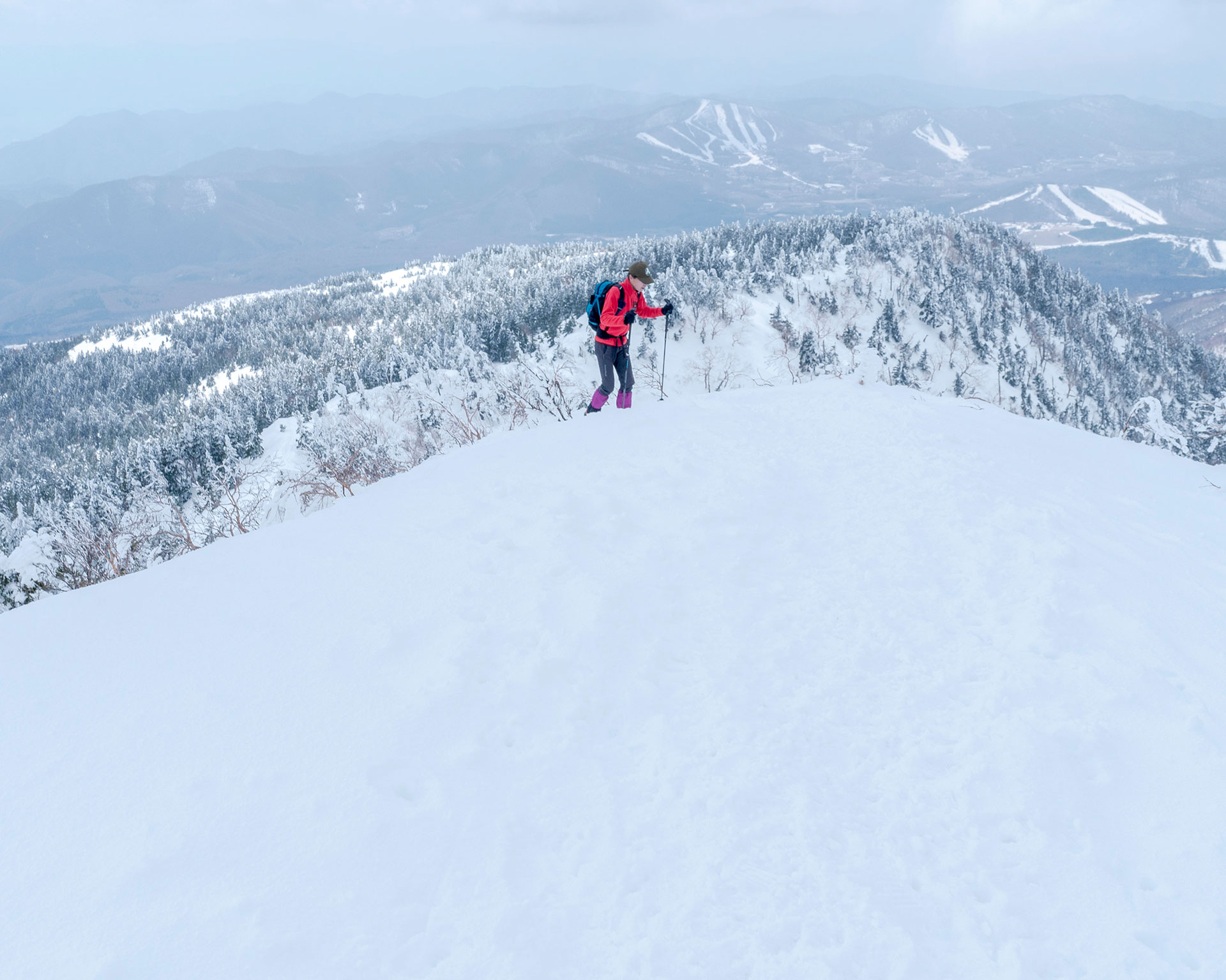 四阿山山頂からの絶景を眺める登山者、スキー場を望む雪山トレッキングの醍醐味