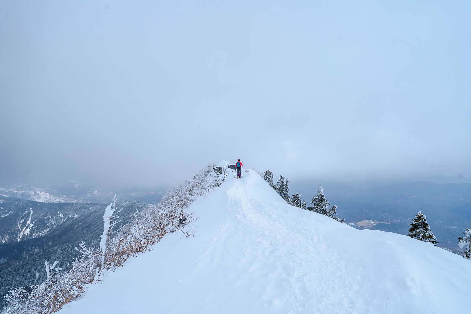 四阿山の雪の稜線を進む登山者、視界良好な冬の縦走路と雄大な眺望