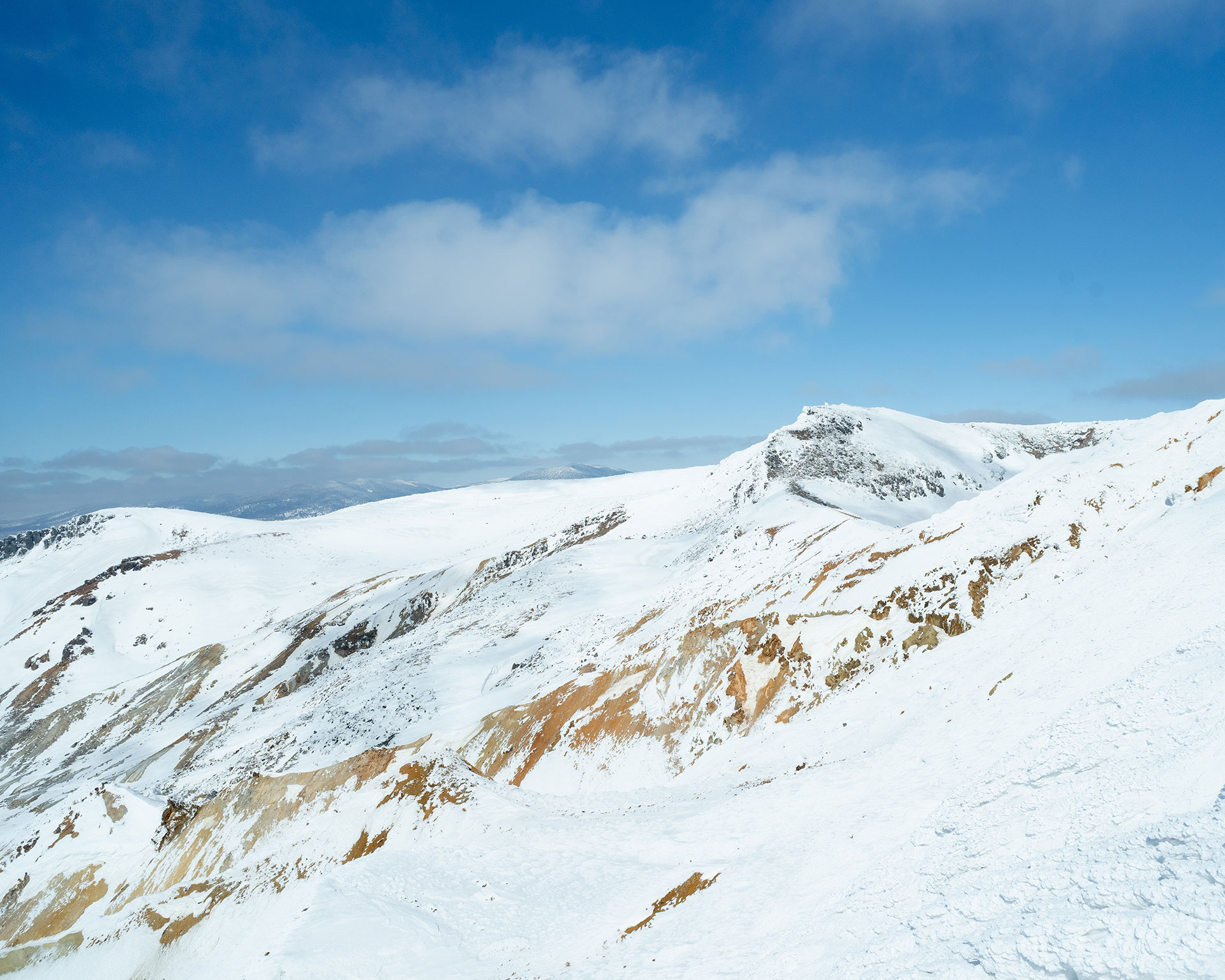 雪山の稜線、茶色の岩肌が部分的に露出している