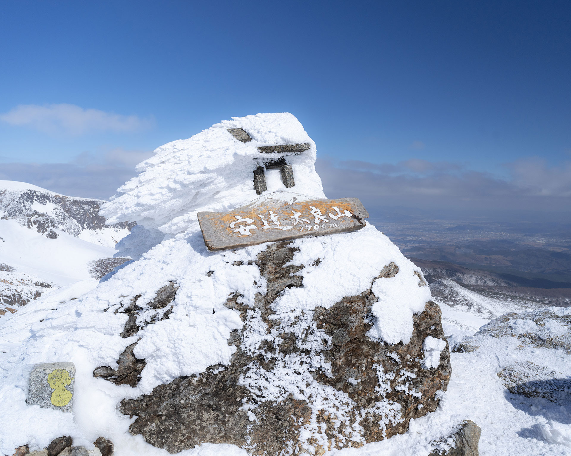 安達太良山山頂の標識、雪と氷に覆われた岩の上