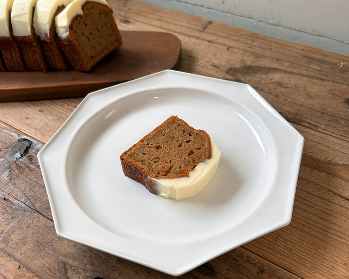 白い八角形の皿にクリームチーズフロスティング付きキャロットケーキのスライス