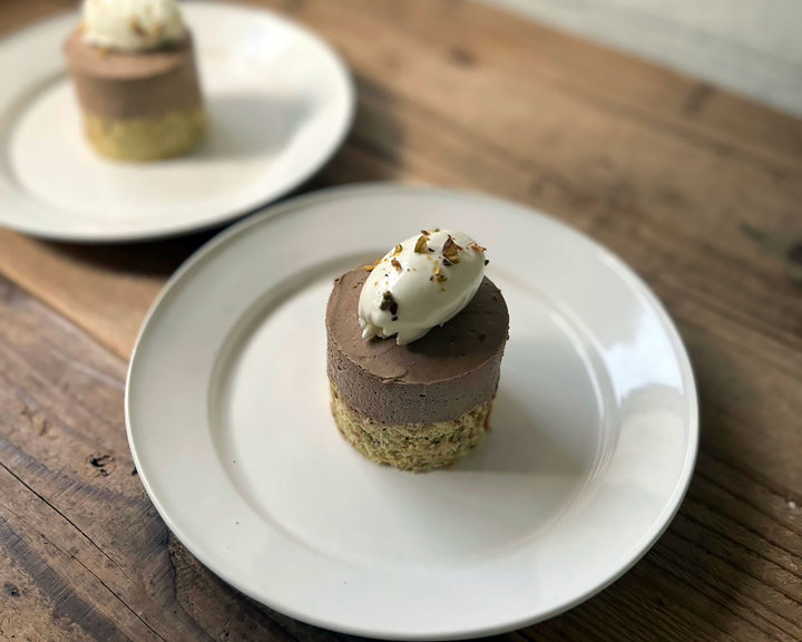 ホイップクリームとナッツをトッピングしたチョコレートムースケーキ