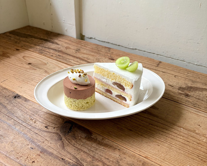 チョコレートムースケーキとぶどうのショートケーキが盛られた白い皿