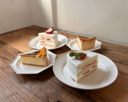 木製テーブルに並べられたショートケーキとチーズケーキ